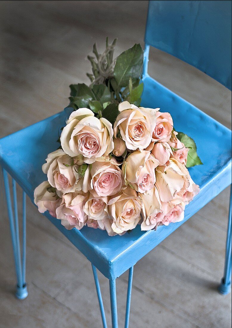 A bunch of pink roses in a blue stool