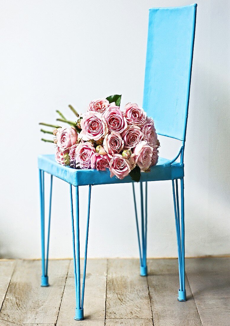 Rosa Rosenstrauss auf türkisblauem Stuhl