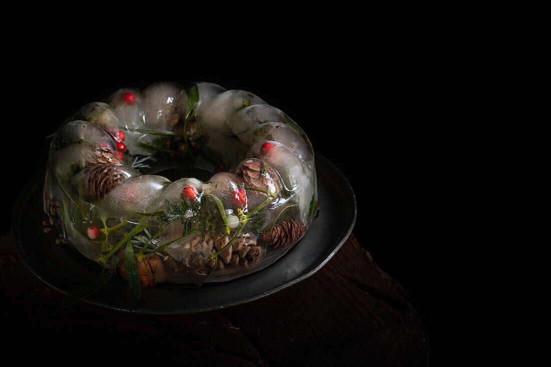  Christmas decoration with ice ring filled with holly, cones and needles 