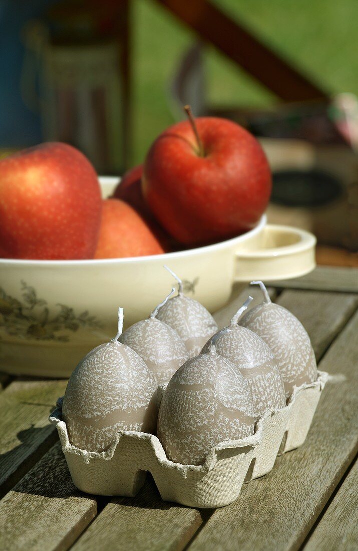 Egg-shaped candles and apples
