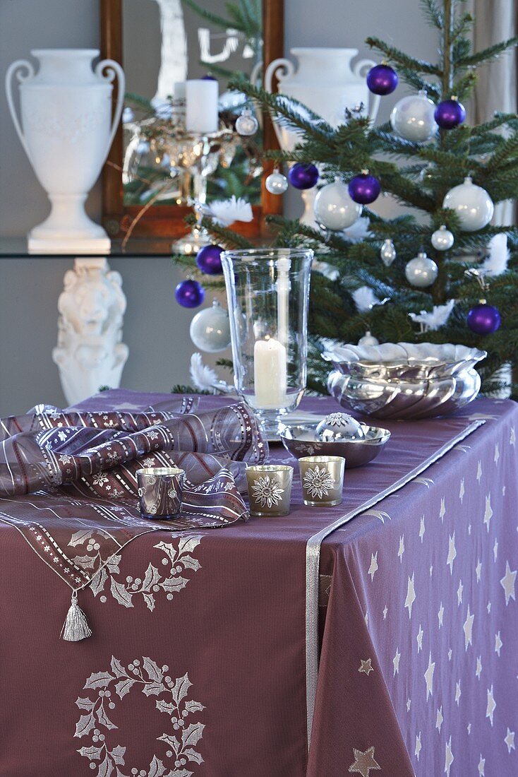 A wall table decorated for Christmas with a Christmas tree next to it