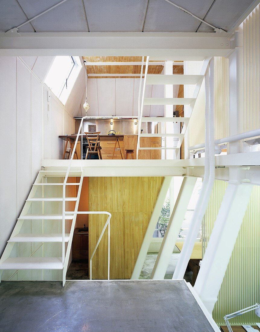 A multi-storey open-plan office with a white metal stairway and galery