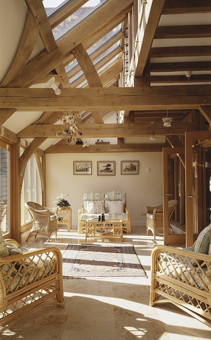 A country house with wooden beams and a wicker furniture in the living room