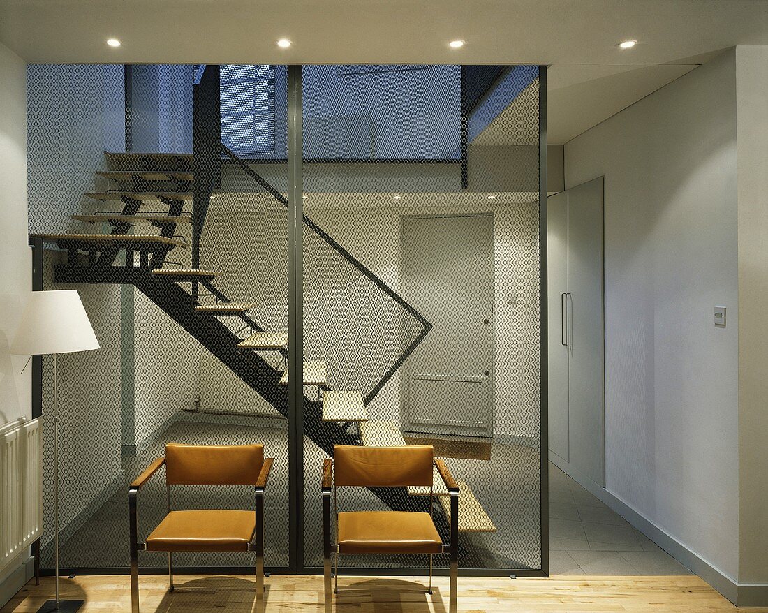 Modern leather chairs in front of a transparent wall panel in a stairwell