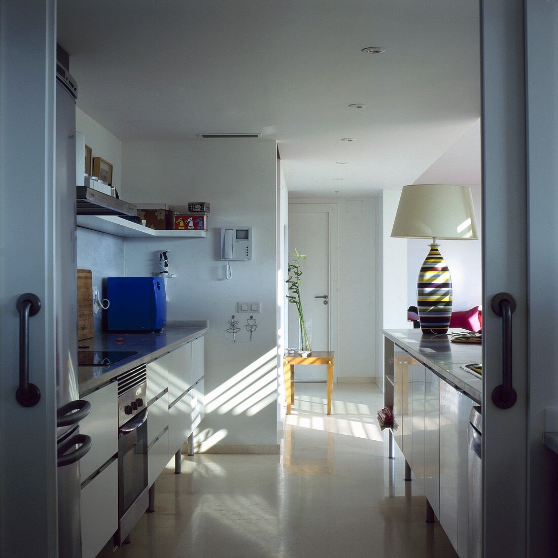 An open-plan kitchen with white cupboards