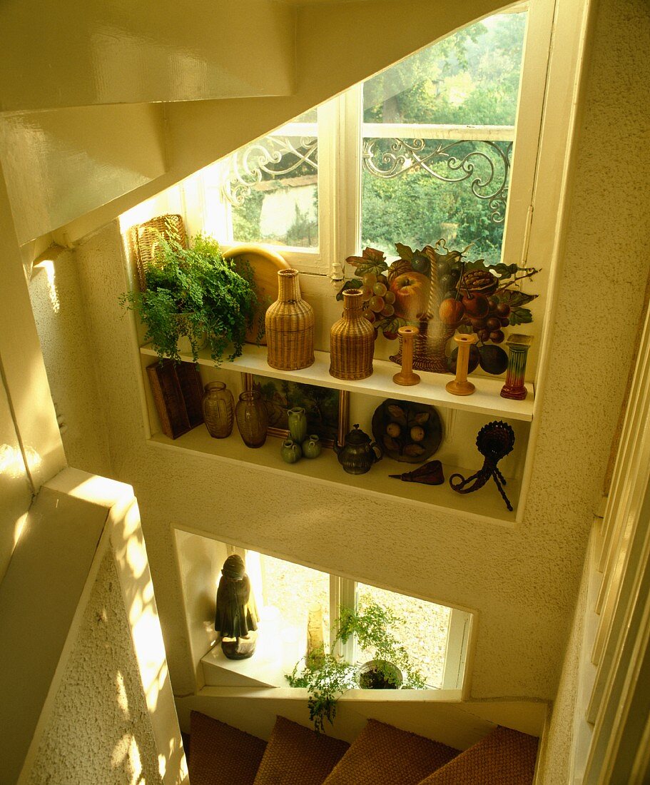 Sisalteppich auf Treppe unter Fenster mit Dekoartikeln auf Borden
