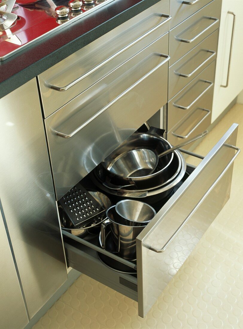 Moderne Küchenzeile aus gebürstetem Stahl mit Edelstahl-Schüsseln in offener Schublade