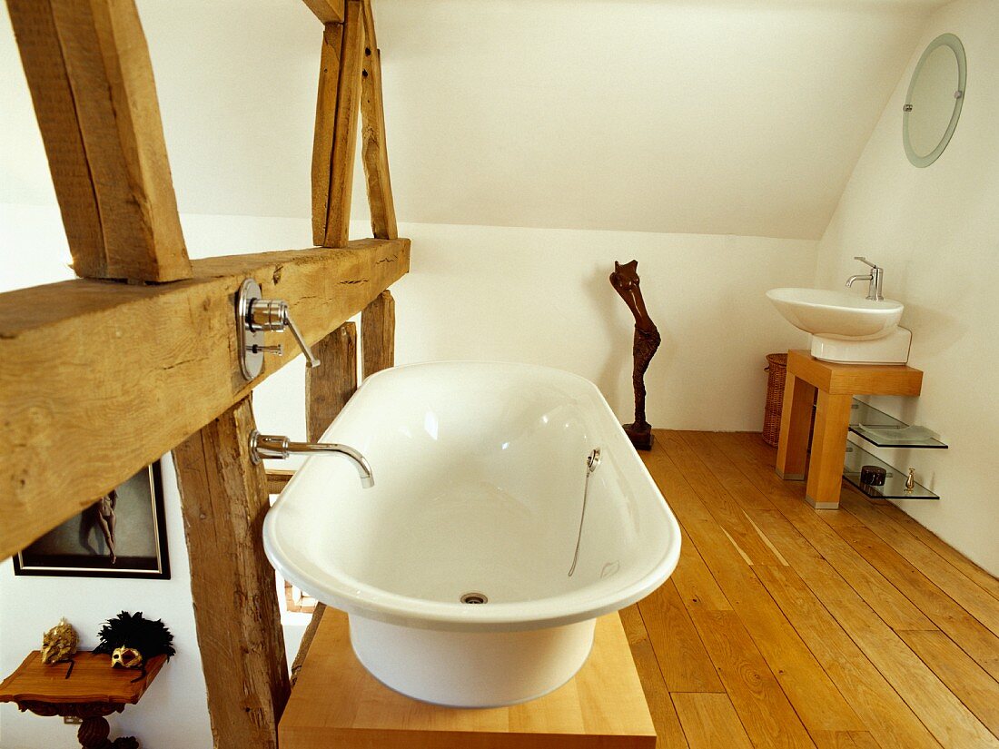 Galerie in umgebauter Scheune als modernes, weisses Bad ensuite mit freistehender Badewanne und Waschbecken auf Holzpodesten