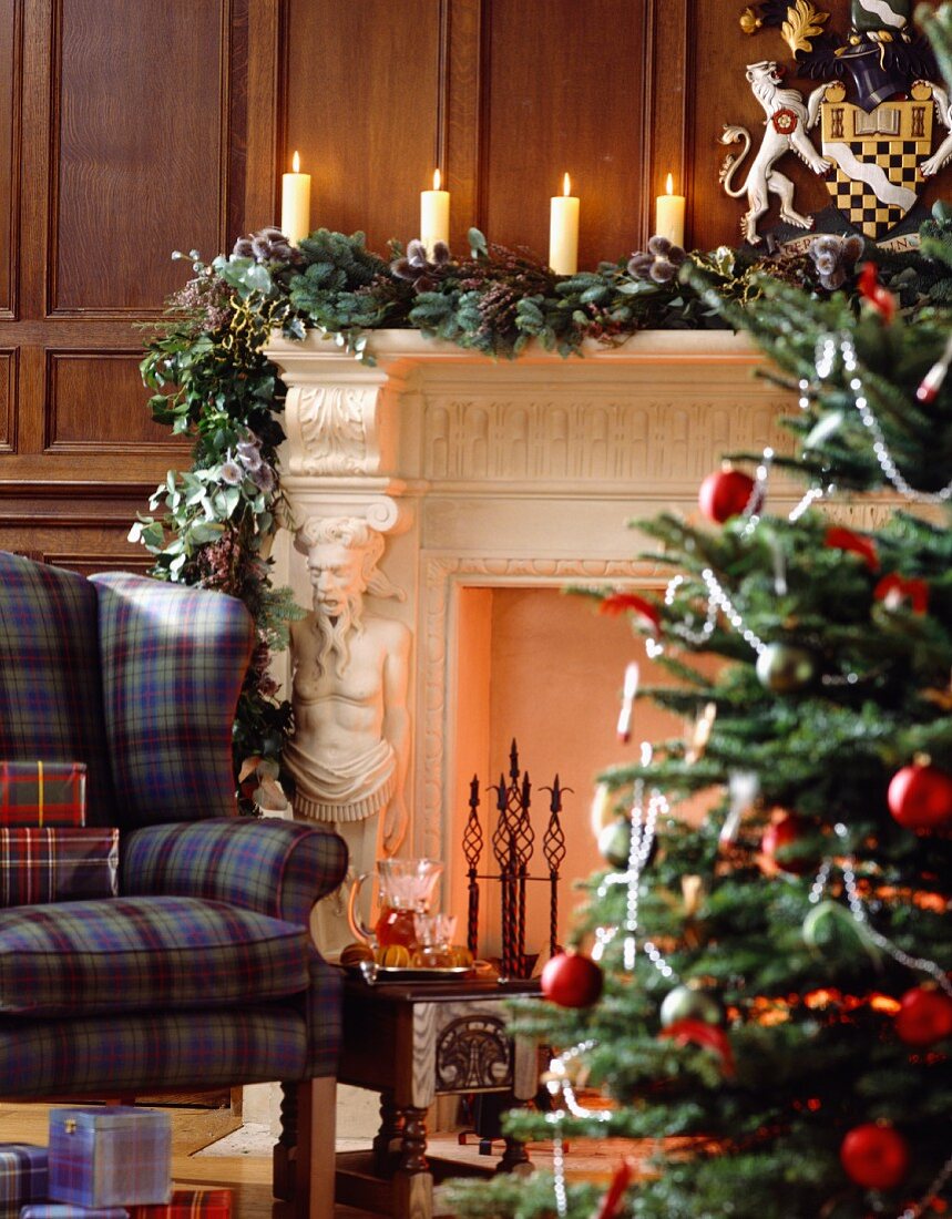 Weihnachtliches Ambiente vor weiss umrahmtem Kamin mit figürlichem Pilaster in traditionellem Wohnzimmer