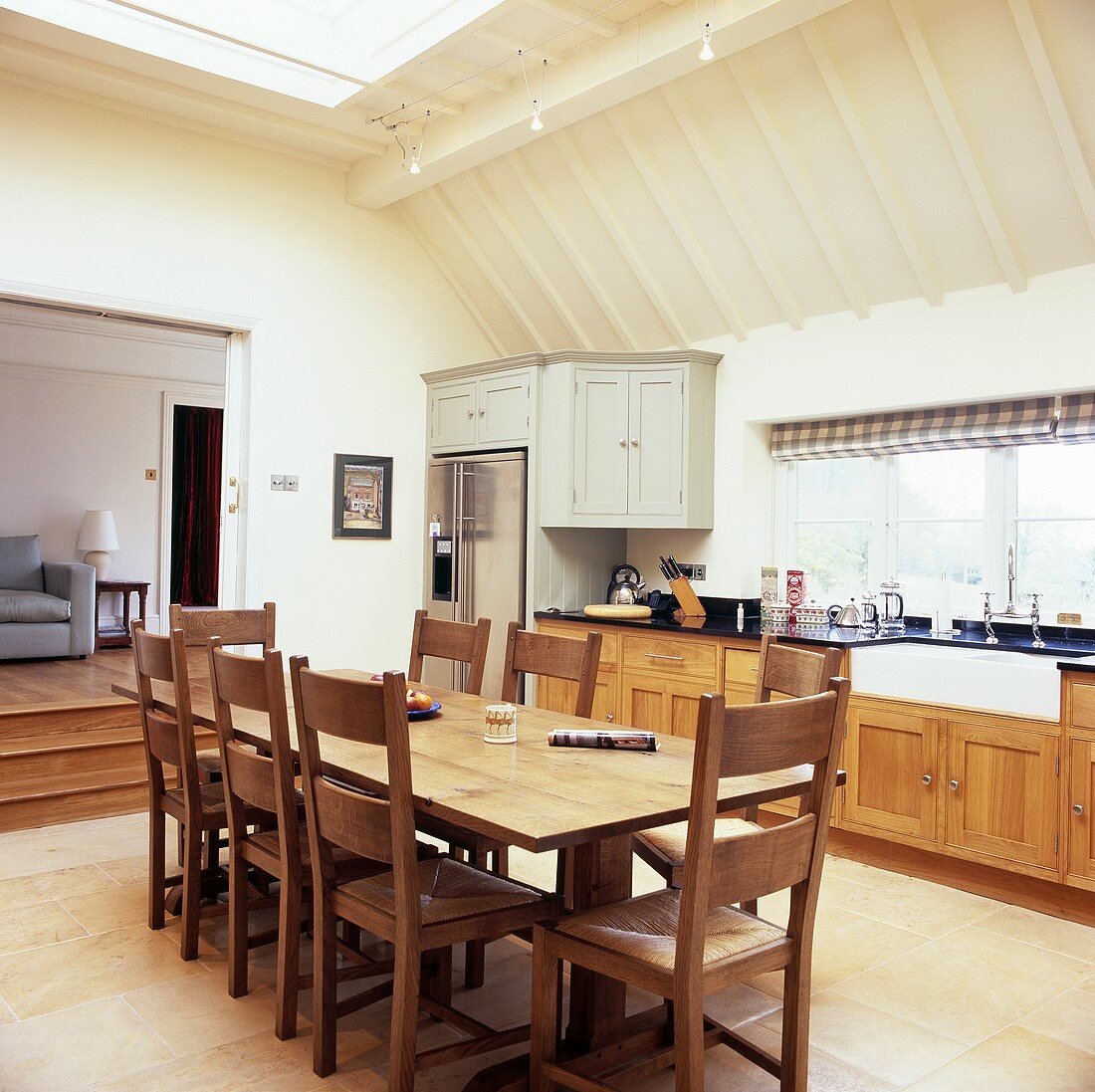 Essbereich mit langem Holztisch und Stühlen in einer cremefarbenen Küche