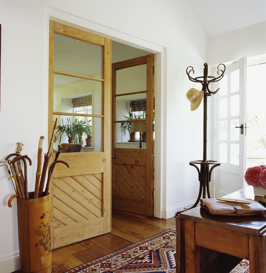 Halb verglaste Doppeltür zwischen Wohnzimmer und Eingangsbereich mit Bugholz-Garderobenständer und bemaltem Spazierstockhalter