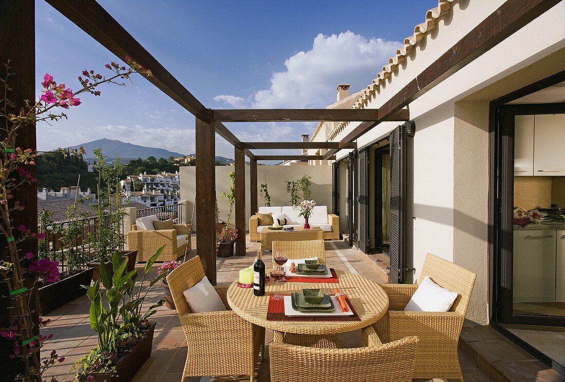 Rattanmöbel auf einem grossen Balkon der spanischen Ferienwohnung mit Blick auf die Berge