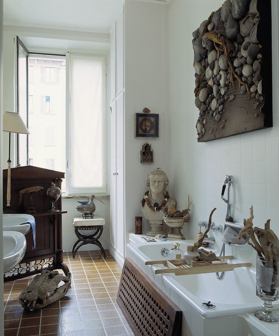 Collage über der Badewanne in einem weissen Badezimmer mit einer Sammlung von Skulptur und Treibholz