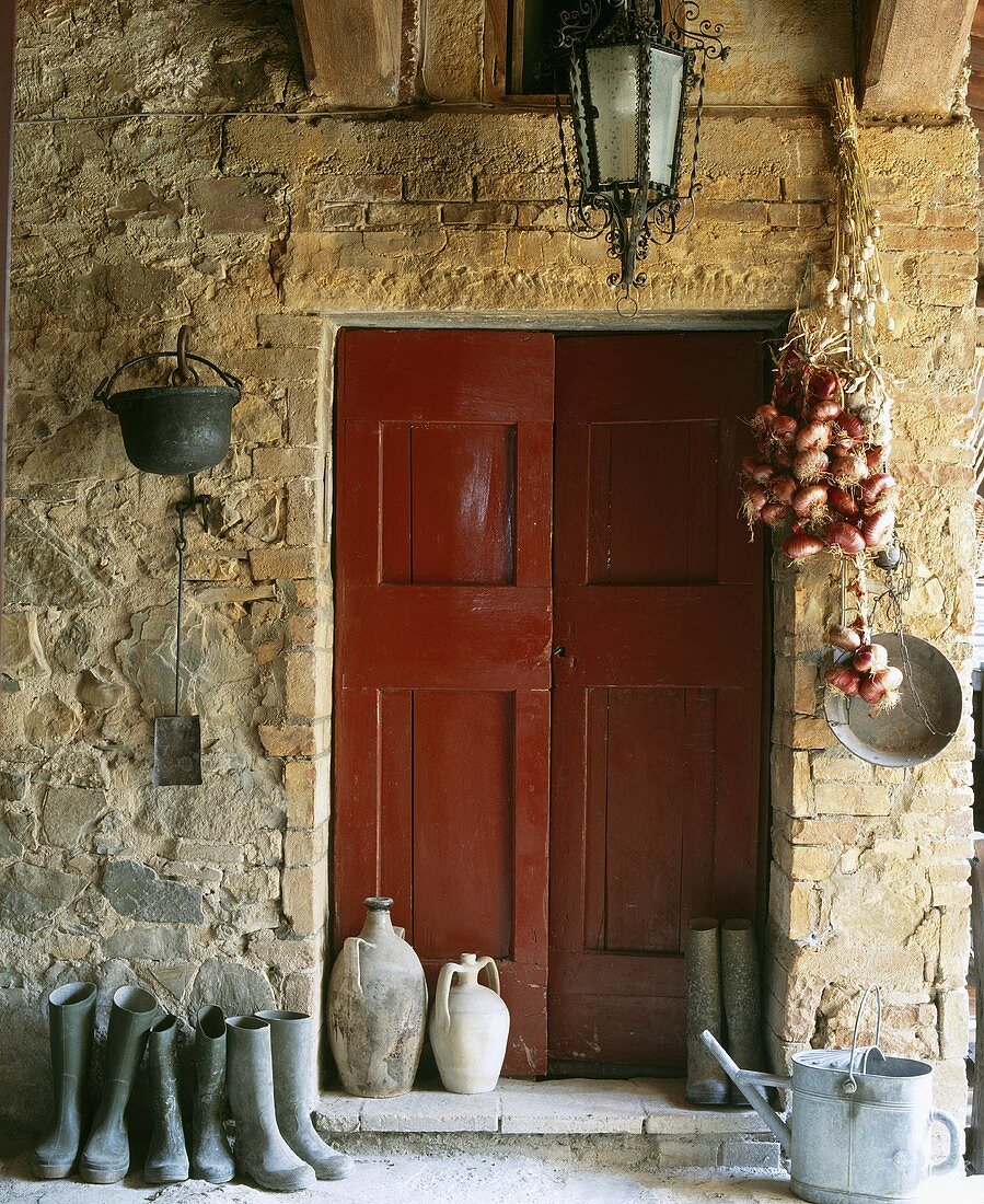 Gummistiefel neben der Doppeltür eines italienischen Landhauses