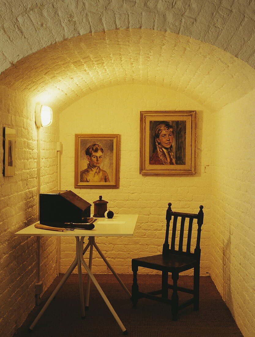 Tisch und Stuhl im Keller Studio mit Bildern an der Wand