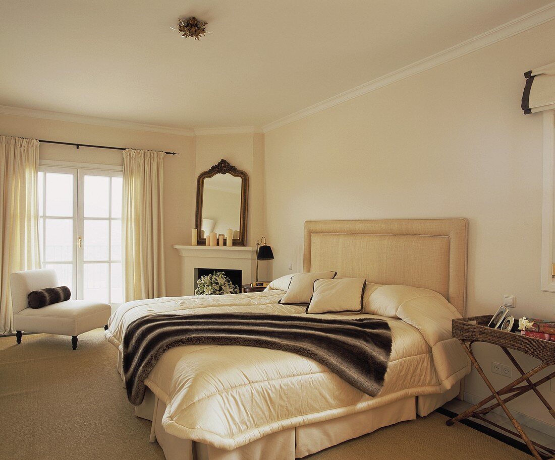 Webpelz am Bett mit Cremefarbenen Polsterkopfteil und Überwurf im modernen Zimmer mit beigefarbenem Teppich