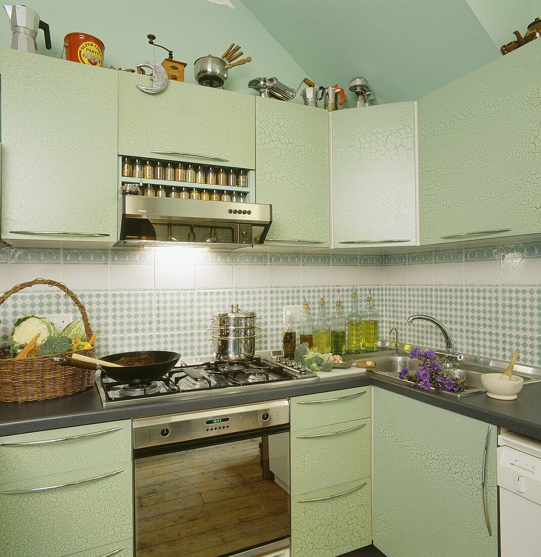 Ein Wok steht auf dem Gasherd der lindgrünen und modernen Küche