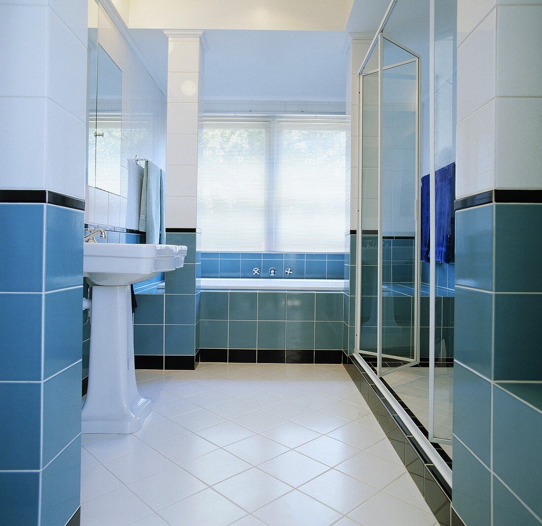 Säulenwaschbecken in modernem, weißem Bad mit türkisblauem Fliesenstreifen an der Wand