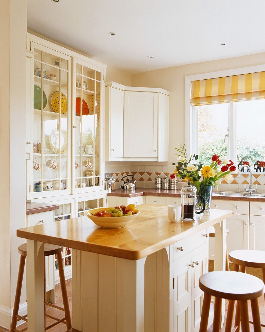 Moderne Küche mit weiss lackierten Fronten, Naturholz-Arbeitsflächen und Küchenblock als Frühstücksbar