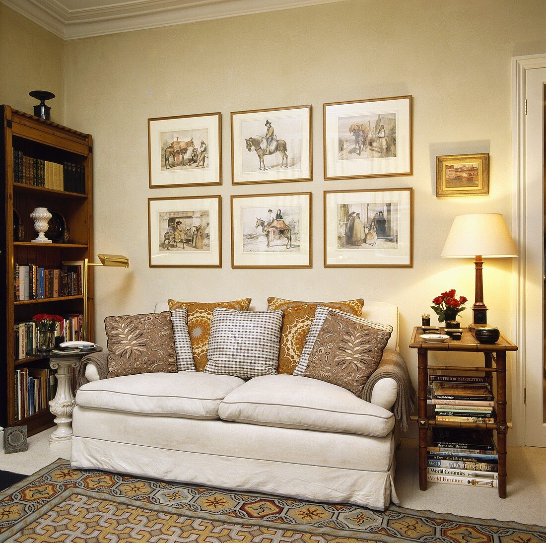 Beigefarbenes Sofa mit einem Beistelltisch unter eingerahmten Bildern in einem Wohnzimmer