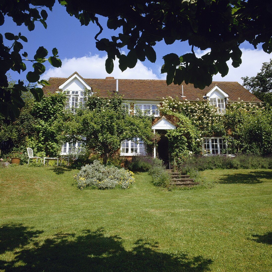 Grosser Garten mit Rasenfläche vor einem Landhaus