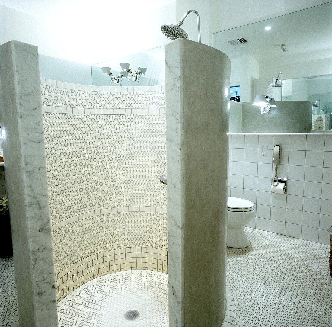 Gekachelter, runder Duschraum in einem großen Badezimmer mit Toilette
