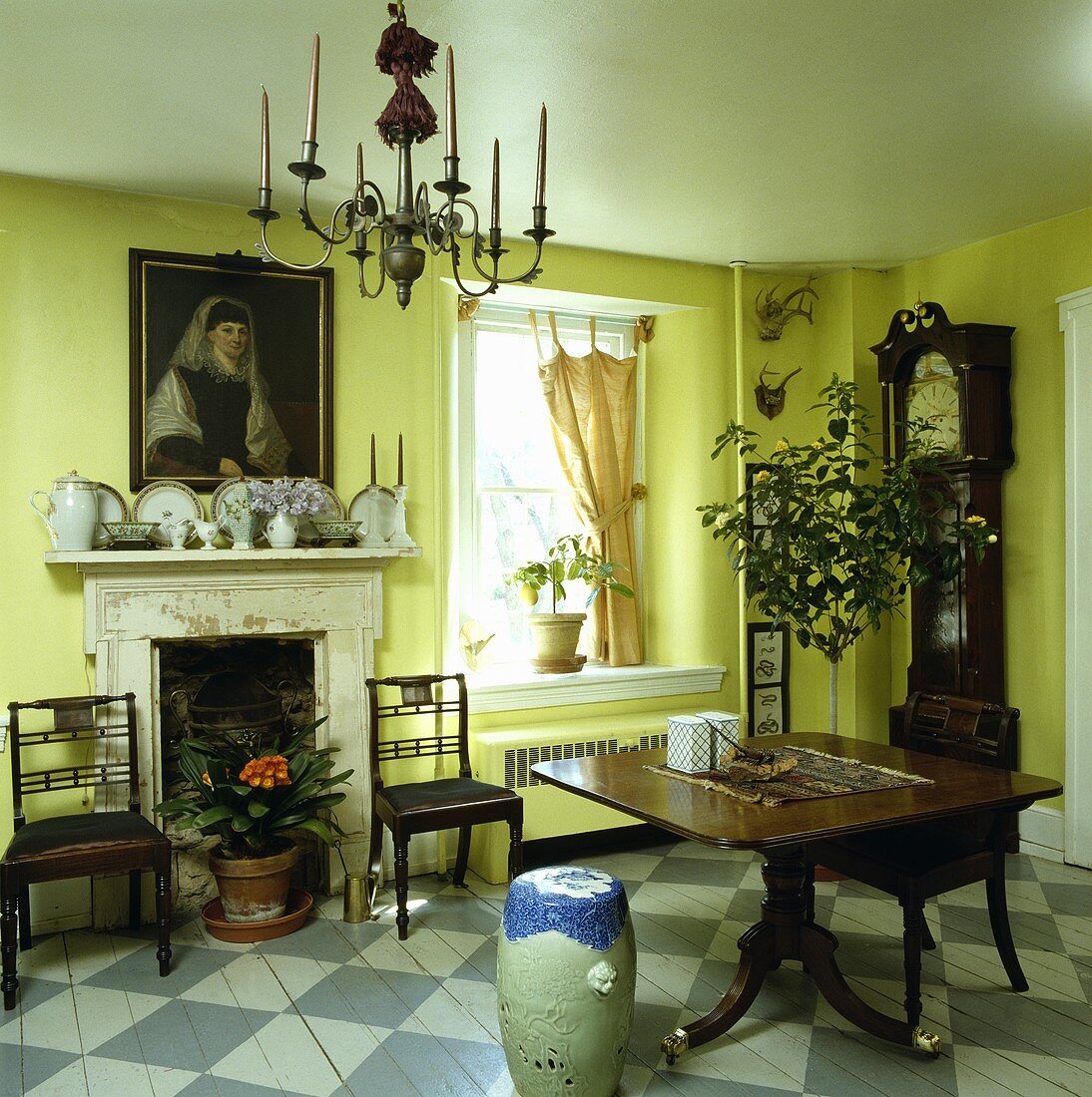 Gelbes Esszimmer mit antiken Möbeln, Standuhr und Boden mit blau-weißem Schachbrettmuster