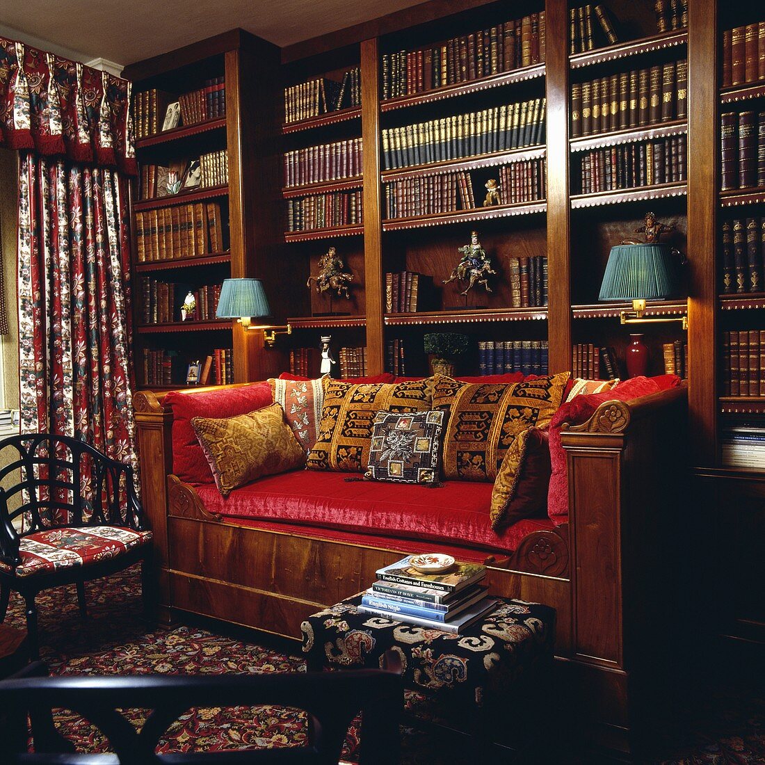 Bibliothek mit rotem Sofa vor einem großen Bücherschrank