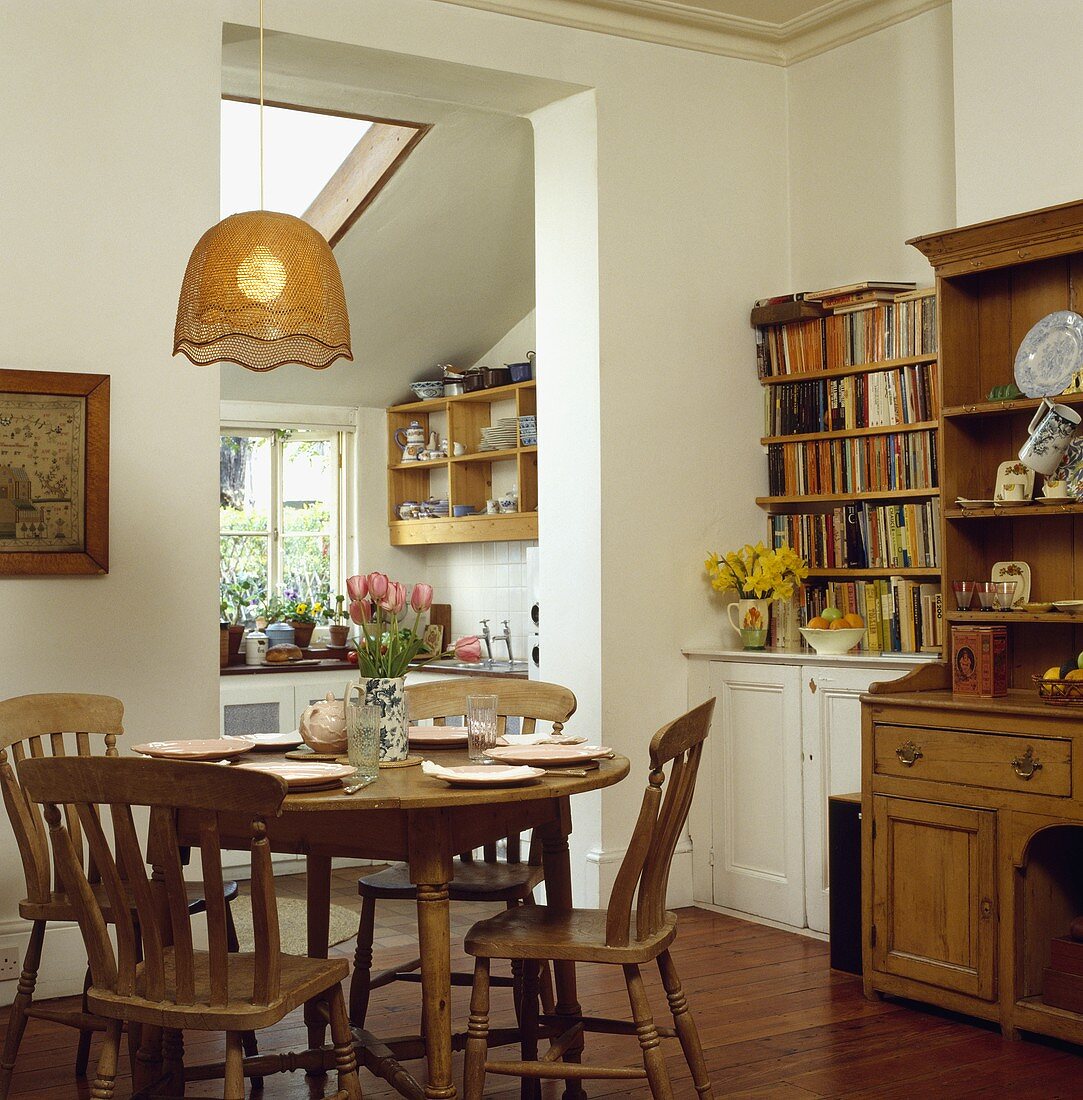 Runder Tisch und Stühlen aus Kiefernholz, eine Anrichte und Bücherregal in einem Esszimmer