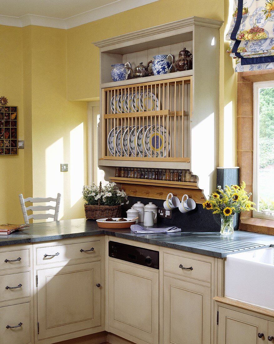 Pastellgelbe Küche mit Tellerboard, eingebautem Geschirrspüler und Granitarbeitsplatten