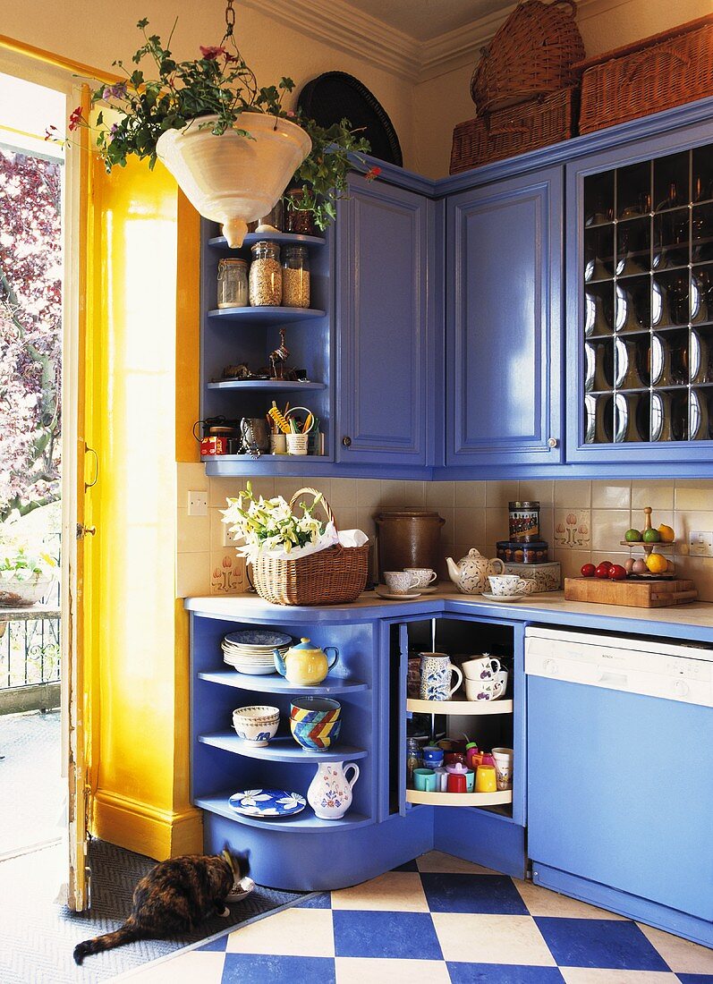 Küchenecke mit blauen Einbauschränken im Landhausstil und Schachbrettmusterboden