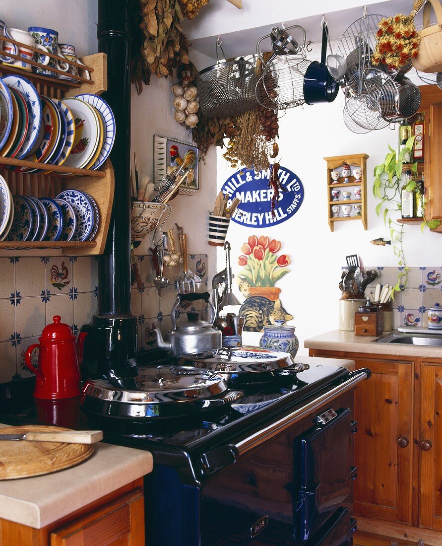 Vintage Küchenecke mit schwarz lackiertem Herd und gemusterten Tellern im Wandboard