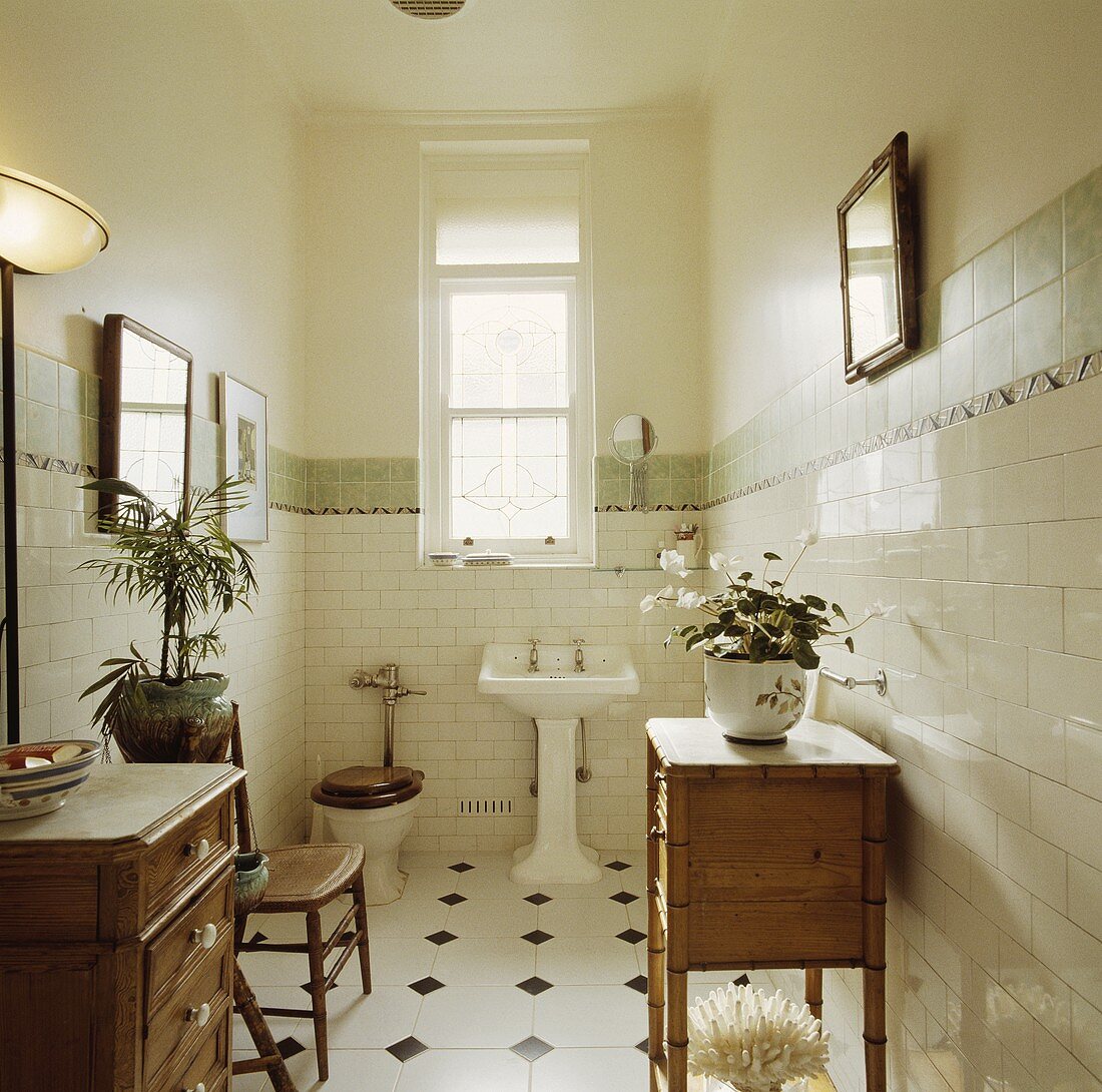 Antiker Schrank und Kommode aus Kiefernholz in einem weiss gefliesten Badezimmer