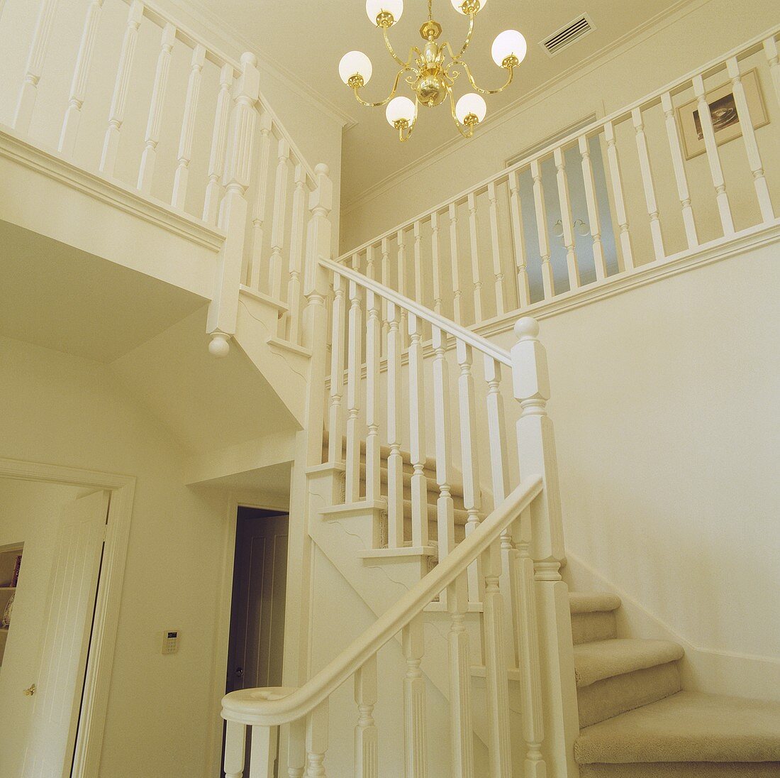 weiße Halle mit Treppenaufgang zum Zwischengeschoss