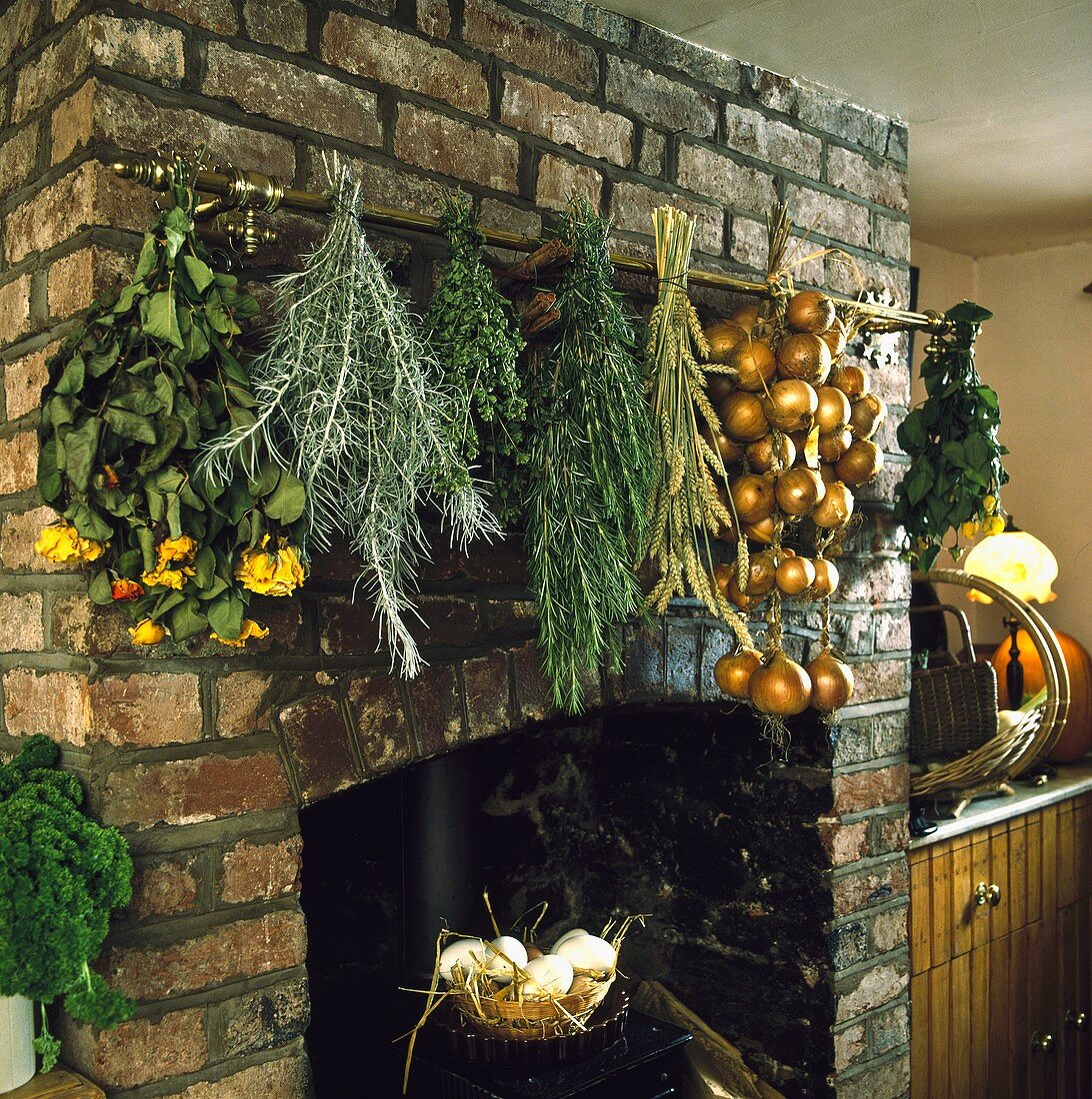 Getrocknete Kräutersträusse am Kamin hängend vor Natursteinwand