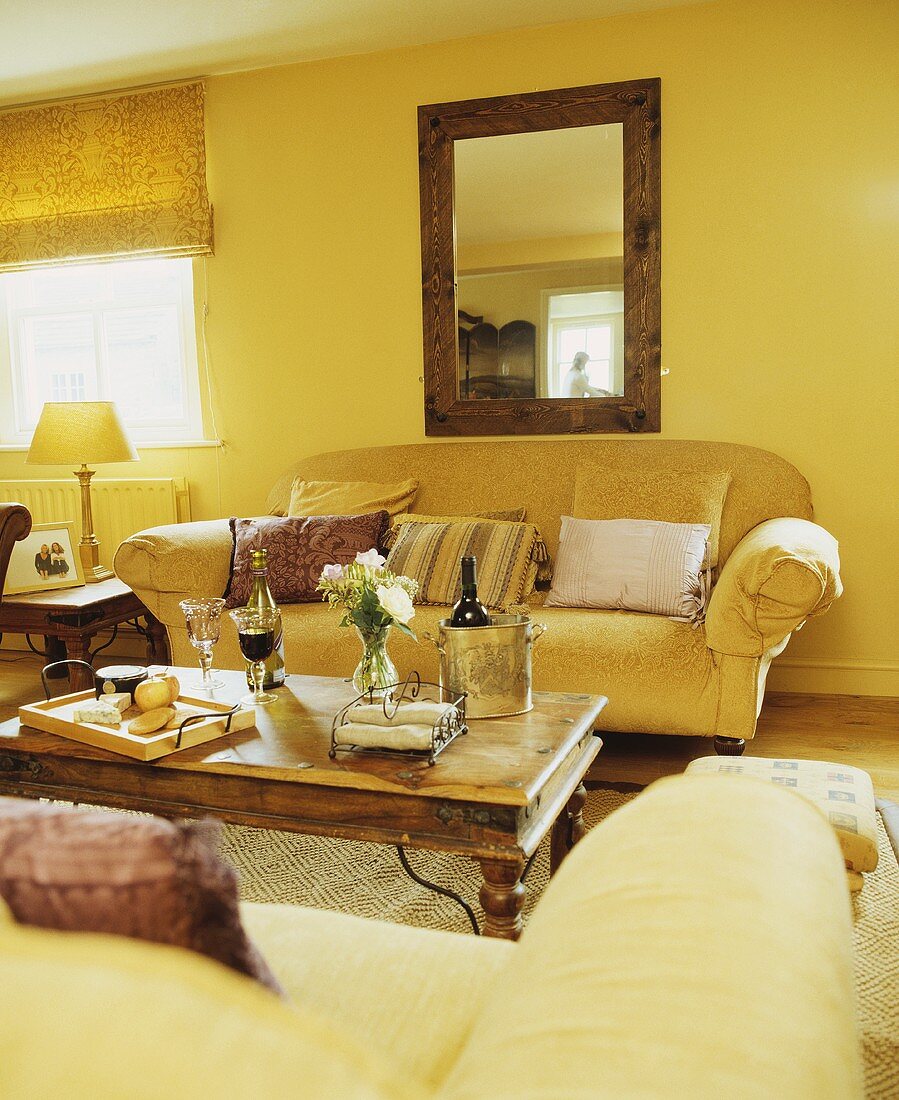 Gelbgetöntes Wohnzimmer mit Polstersofa vor Couchtisch