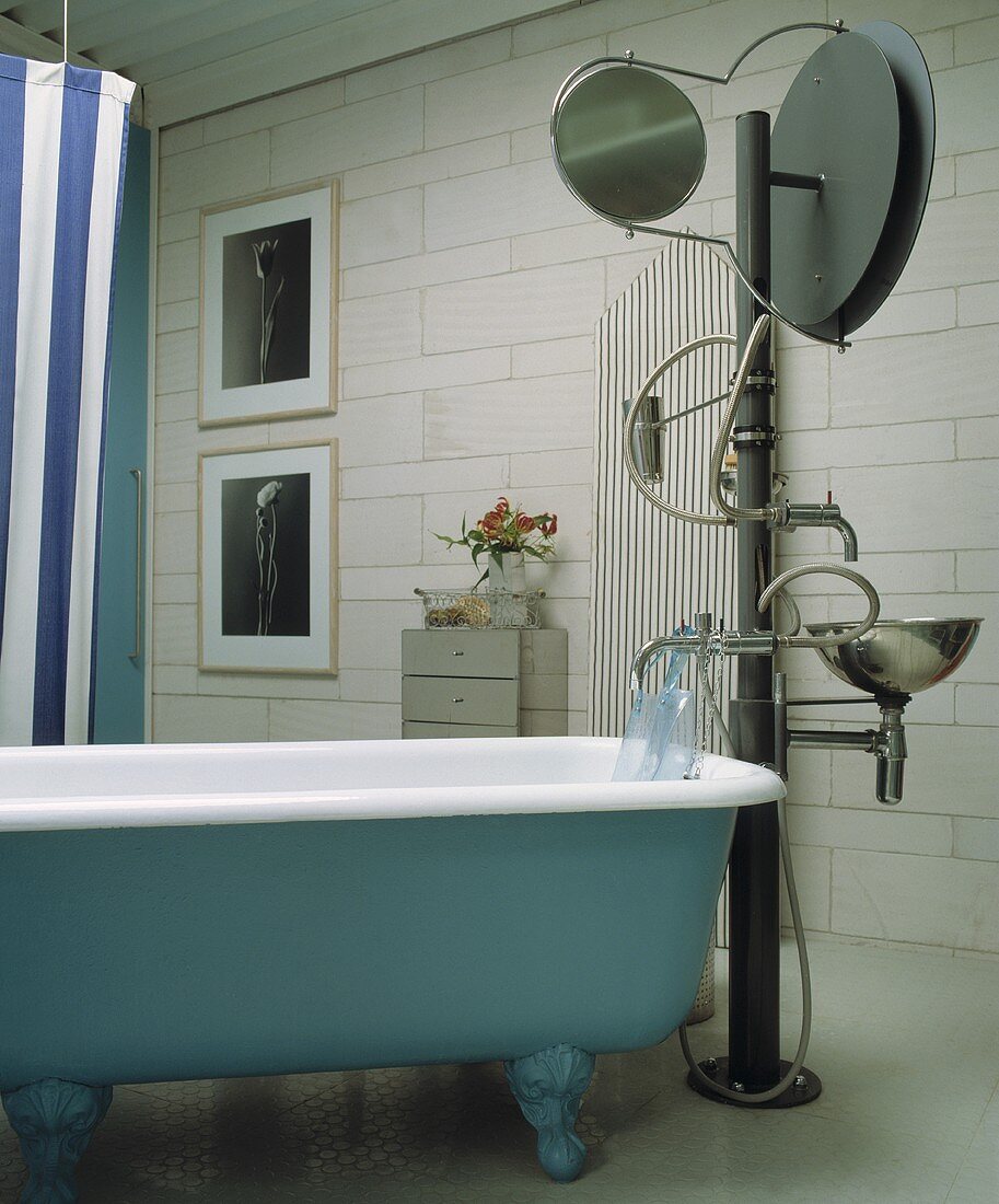 Badewanne im Vintagestil und künstlerische Standarmatur mit Spiegel und Waschbecken an Säule