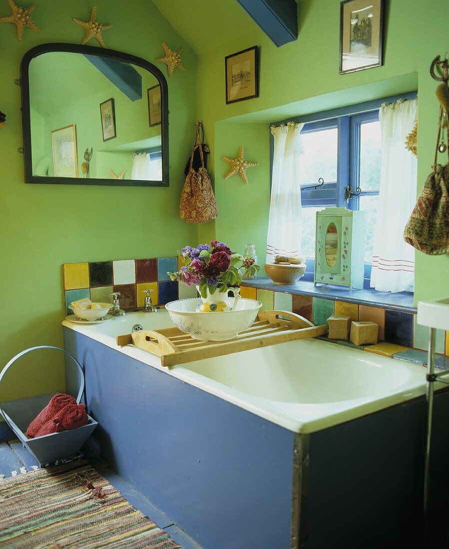 Altes grün gestrichenes Badezimmer unter Dach mit Badewanne am Fenster