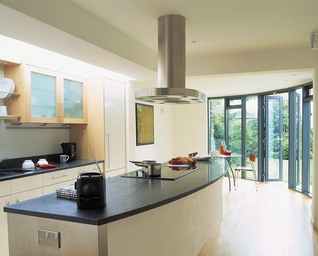 Dunstabzug über Küchenblock mit Arbeitsplatte aus Schiefer in moderner Küche mit Terrassentüren