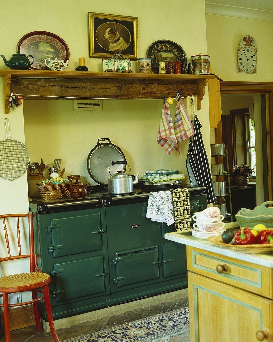 Alte Küche mit grünem Küchenofen vor hellgrüner Wand