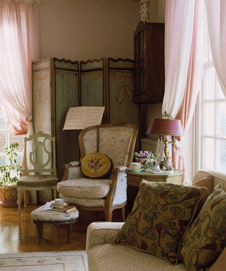 Wohnzimmerecke mit antikem Sessel rosa Gardinen