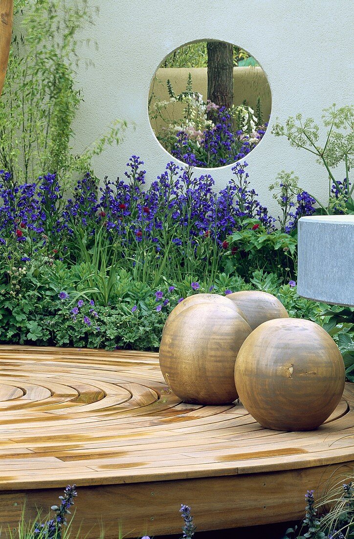 Kugeln auf kreisförmiger Terrasse aus Holz im modernen Garten