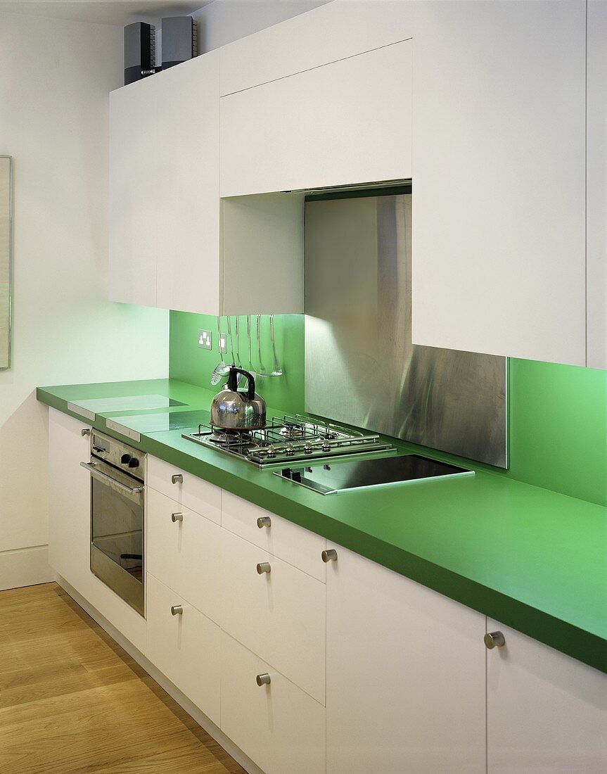 weiße Küche mit grüner Arbeitsplatte und Spritzschutz