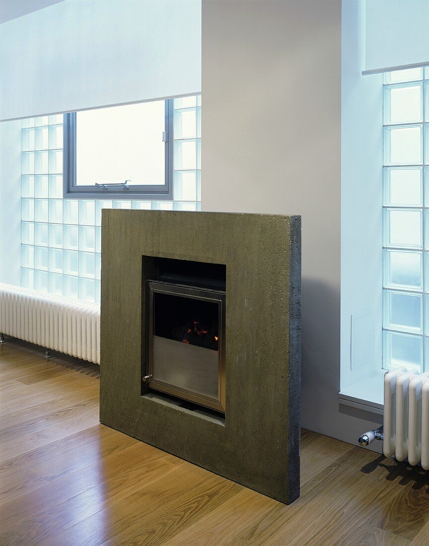 A modern fireplace with a stone frame and a glass stone wall
