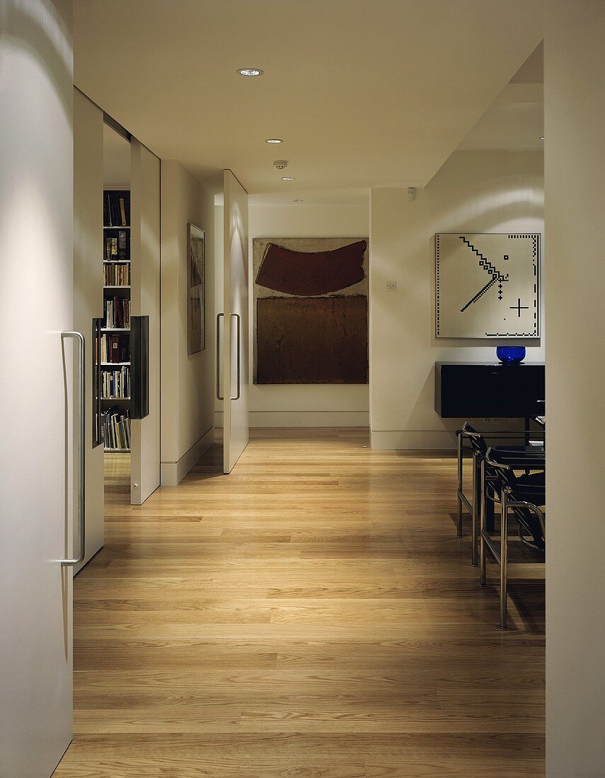 A view into a living room with parquet flooring and open doors