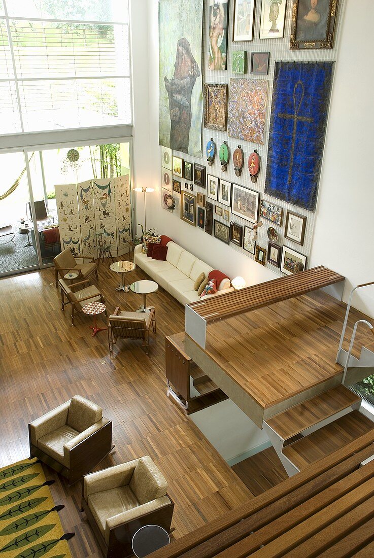 A view of a living room with upholstered furniture, parquet flooring and an open flight of stairs in a newly built house
