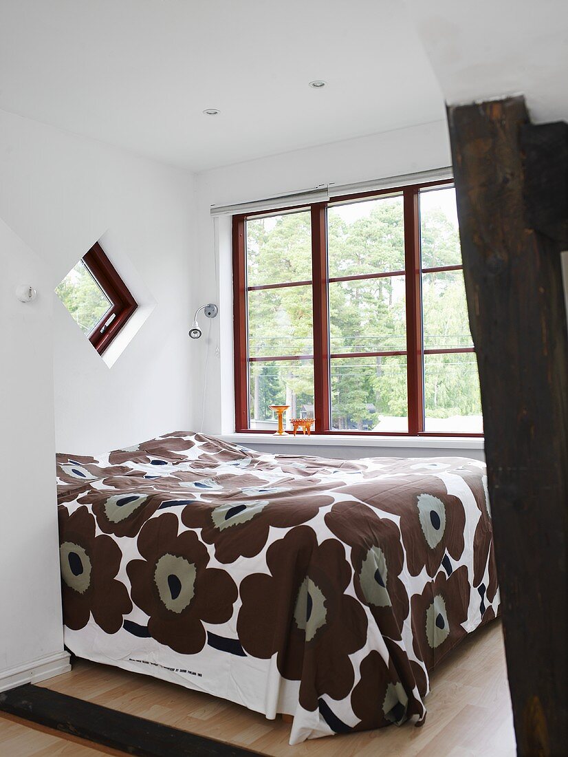 A double bed with a brown patterned quilt in a bedroom