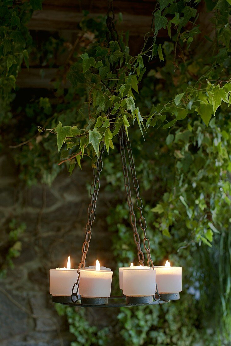 A candle holder under ivy on a terrace