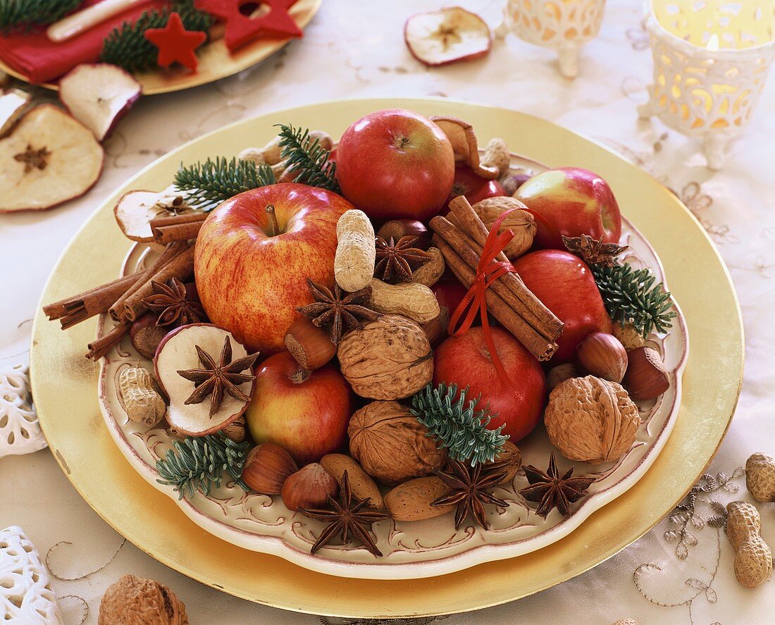 Plate of apples, nuts, star anise and cinnamon sticks