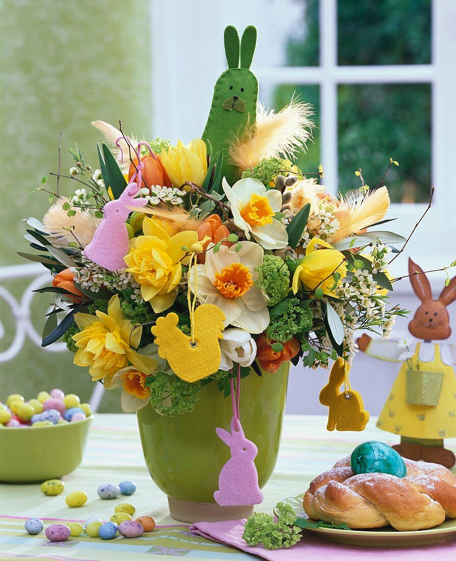 Easter arrangement of narcissi and tulips in green vase